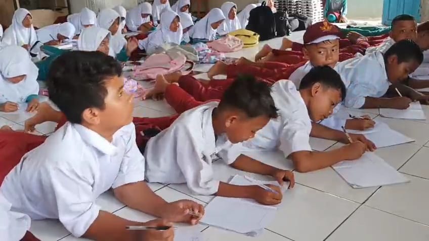 proses pembelajaran dalam kondisi yang jauh dari kata layak. Sejak dua ruang kelas ambruk pada 2023, sebanyak 38 siswa kelas V terpaksa belajar di lantai musala sekolah.
